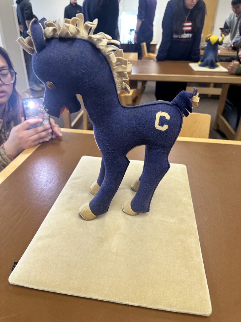 Carleton pony stuffed animal and Trixie in the background holding a flashlight during the 3d modelling process