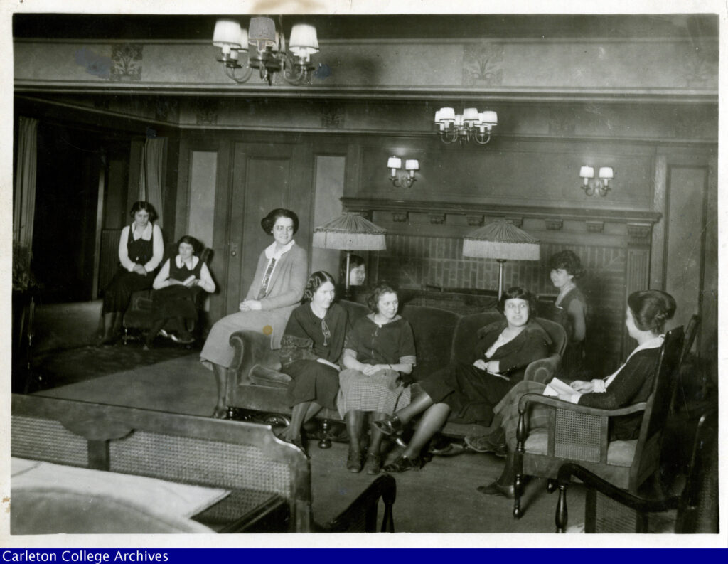 original black and white image of the inside of Nourse Hall with nine Carleton female students